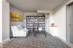 Living area featuring a patterned carpet, built-in shelving, and light gray walls - 