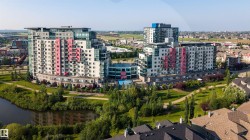 Two modern multi-story buildings featuring balconies and a mix of white, grey, and pink exterior panels - 