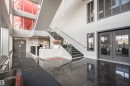 Spacious lobby with high ceilings, dark polished tile flooring, and a contemporary reception desk - #610 5151 Windermere Bv Sw, Edmonton, AB  - Indoor Photo Showing Other Room 