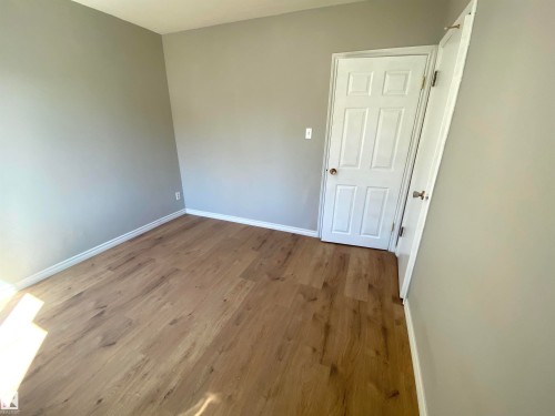 Wood-finish flooring with light gray walls and white trim - 12010 66 Street Nw, Edmonton, AB 