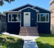 Dark exterior with white trim, featuring a white entry door with an arched window - 12010 66 Street Nw, Edmonton, AB 