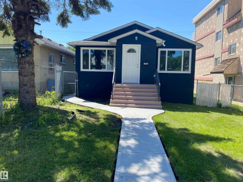 Dark blue exterior with white trim, new concrete walkway, new front steps, and a fenced side yard - 12010 66 Street Nw, Edmonton, AB 