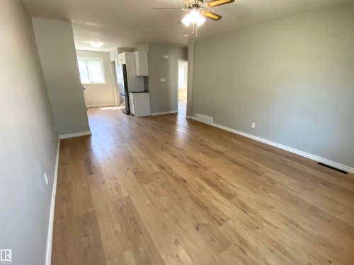 Wood-finish flooring throughout, light gray wall finishes, recessed ceiling light fixtures, and a ceiling fan - 12010 66 Street Nw, Edmonton, AB 