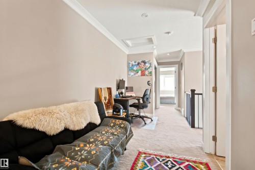 Carpeted hallway with crown molding, recessed lighting, and a skylight - 10833 63 Avenue Nw, Edmonton, AB 