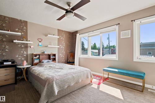 Ceiling fan with integrated lighting, multiple windows, wood-finish flooring, and built-in shelving - 10833 63 Avenue Nw, Edmonton, AB 