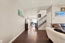 Dark wood-finish flooring throughout, recessed lighting, and a staircase with a dark wood handrail and metal spindles - 10833 63 Avenue Nw, Edmonton, AB 