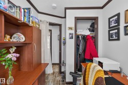 Interior space featuring wood-finish flooring, white walls, and dark brown trim - 