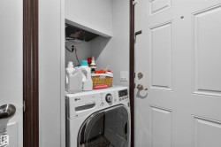Dedicated laundry area featuring a front-load washer and upper shelving - 