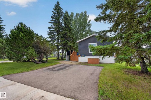 Exterior featuring dark gray siding with white trim, a white foundation, and a wooden deck - 4204 47 Street, Wetaskiwin, AB - Outdoor