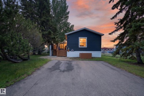Single-story residence featuring dark blue horizontal siding, white trim, and a gabled roofline - 4204 47 Street, Wetaskiwin, AB - Outdoor