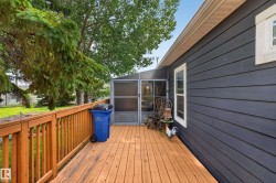 Expansive wood-finish deck with railing, providing outdoor living space - 