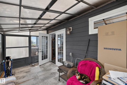 Sunroom featuring a translucent panel roof, textured gray exterior siding, and French doors - 4204 47 Street, Wetaskiwin, AB - Indoor