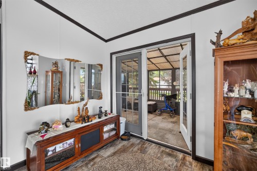 Glass-paneled French doors opening to a sunroom with a white railing - 4204 47 Street, Wetaskiwin, AB - Indoor Photo Showing Other Room