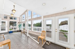 Sunroom with expansive windows, recessed lighting, and tile flooring - 