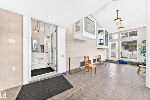 Tile flooring extending to a tiled wall, multiple bay windows, and built-in lighting fixtures - 3311 104 Avenue Nw, Edmonton, AB 