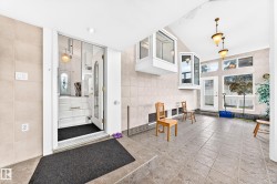 Tile flooring extending to a tiled wall, multiple bay windows, and built-in lighting fixtures - 