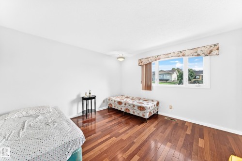 Hardwood-finish flooring, white walls, and a multi-pane window with a valance - 3311 104 Avenue Nw, Edmonton, AB 