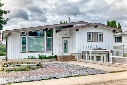 White vertical siding exterior with brown trim accents - 3311 104 Avenue Nw, Edmonton, AB 