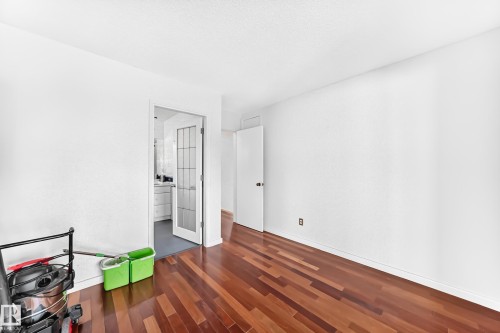 Rich wood-finish flooring with white walls and ceiling - 3311 104 Avenue Nw, Edmonton, AB 
