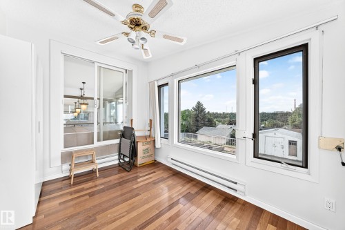 Hardwood flooring, white painted walls, large picture windows, and a ceiling fan with integrated lighting - 3311 104 Avenue Nw, Edmonton, AB 