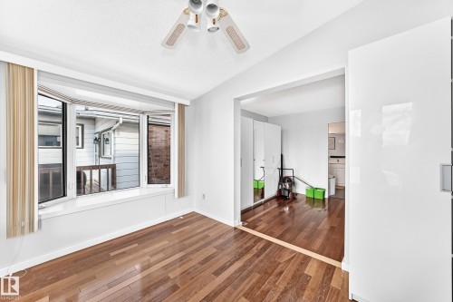 Hardwood flooring, bay window, ceiling fan, white paneled walls, and a wide entryway - 3311 104 Avenue Nw, Edmonton, AB 