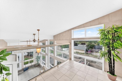 Vaulted ceiling, ceiling-mounted light fixtures, tiled flooring, expansive windows, and a glass-paneled railing - 3311 104 Avenue Nw, Edmonton, AB 