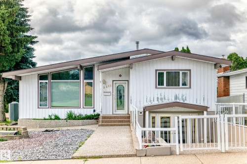 Contemporary exterior architecture with a gently sloped roofline, an accessible ramp, and a concrete driveway - 3311 104 Avenue Nw, Edmonton, AB 