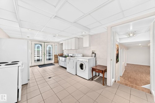 Tile flooring, white cabinetry, double basin sink, double glass panel doors, and recessed lighting - 3311 104 Avenue Nw, Edmonton, AB 
