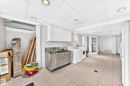 Recessed lighting, tile flooring, stainless steel utility sink, white upper cabinetry, and a white paneled ceiling - 3311 104 Avenue Nw, Edmonton, AB 
