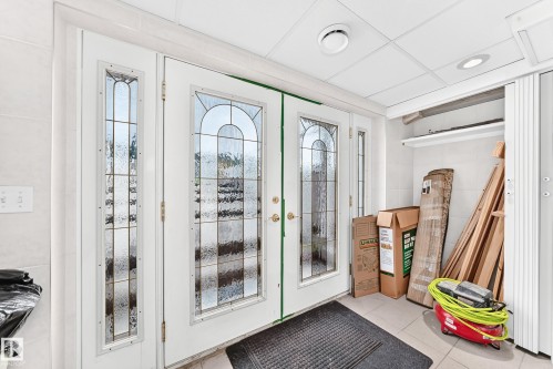 Double entry doors with decorative glass panels and a transom window - 3311 104 Avenue Nw, Edmonton, AB 