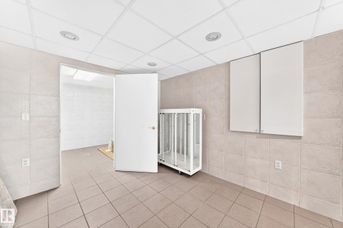 Recessed lighting, drop ceiling, wall-mounted cabinetry, tiled flooring, and tiled walls - 3311 104 Avenue Nw, Edmonton, AB 