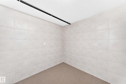 Light-toned wall tiling with a matte finish, complemented by a solid ceiling and dark-toned flooring - 3311 104 Avenue Nw, Edmonton, AB 