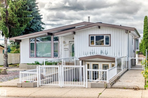 White vertical siding with brown trim accents - 3311 104 Avenue Nw, Edmonton, AB 