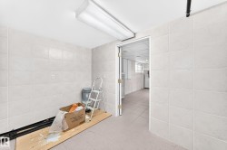 White tile walls, white ceiling, and a flush-mounted fluorescent light fixture - 