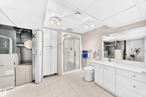 Tile flooring, glass-enclosed shower, built-in vanity with integrated sink, drop ceiling, and recessed lighting - 3311 104 Avenue Nw, Edmonton, AB 