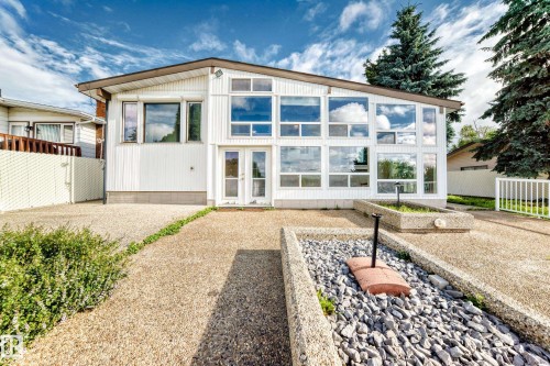 White exterior with a prominent multi-paned window wall - 3311 104 Avenue Nw, Edmonton, AB 