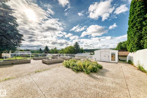 Expansive outdoor patio with concrete pavers, raised garden beds, and a white storage shed - 3311 104 Avenue Nw, Edmonton, AB 