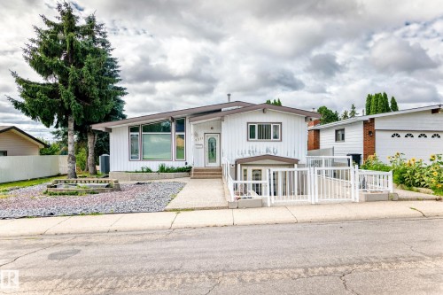 Single-story residence featuring a white vertical siding exterior and a multi-pitch roofline - 3311 104 Avenue Nw, Edmonton, AB 