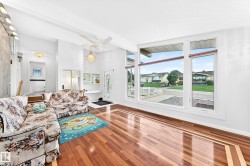 Hardwood-finish flooring with decorative inlay, large picture windows, vaulted ceilings, and a built-in display cabinet - 