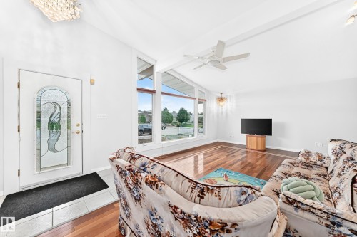 Vaulted ceiling, decorative glass front entry door, wood-finish flooring, large windows, and a ceiling fan - 3311 104 Avenue Nw, Edmonton, AB 