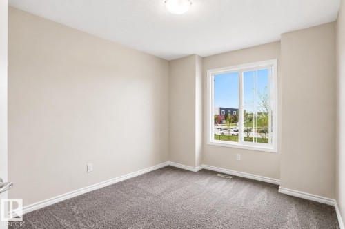 Neutral wall paint throughout, textured ceiling, and a prominent window with white trim - 445 Watt Boulevard Sw, Edmonton, AB 