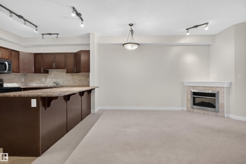 #212 2035 Grantham Ct Nw, Edmonton, AB - Indoor Photo Showing Kitchen With Fireplace