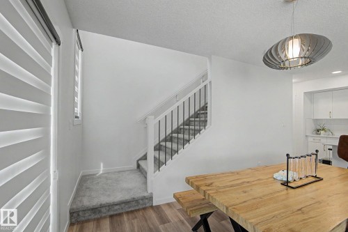 Staircase featuring white risers, carpeted treads, and iron balusters - #12 905 172 St Sw, Edmonton, AB - Indoor Photo Showing Other Room