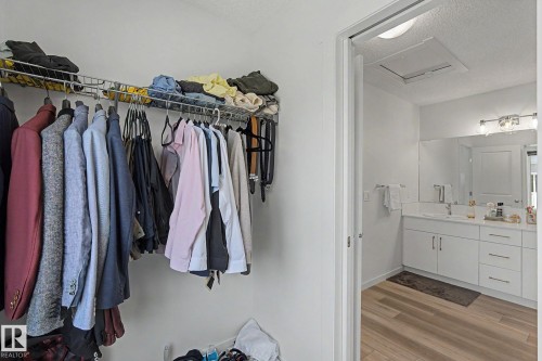 Built-in closet shelving system with metal hanging rods for vertical storage - #12 905 172 St Sw, Edmonton, AB - Indoor With Storage