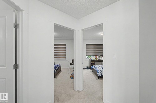 Hallway with white walls and light-toned carpeted flooring - #12 905 172 St Sw, Edmonton, AB - Indoor Photo Showing Other Room