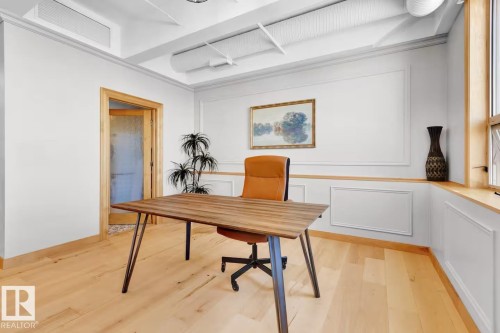 Light wood-finish flooring, white panel molding, exposed ceiling ductwork, and light wood-finish trim - #903 10105 109 St Nw, Edmonton, AB 