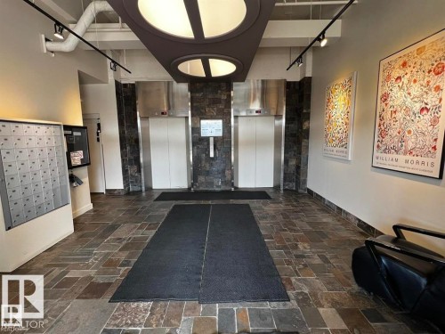 Dual elevators with stainless steel doors and stone-finish surrounds - #903 10105 109 St Nw, Edmonton, AB 