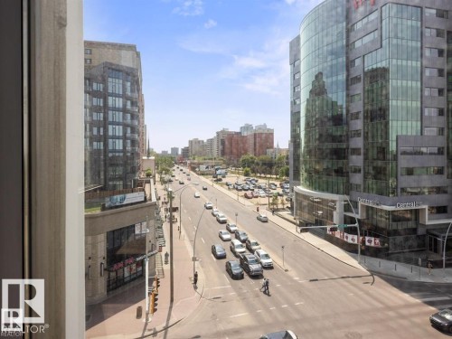 Urban streetscape with multi-story commercial and residential buildings, a thoroughfare, and a parking area - #903 10105 109 St Nw, Edmonton, AB 
