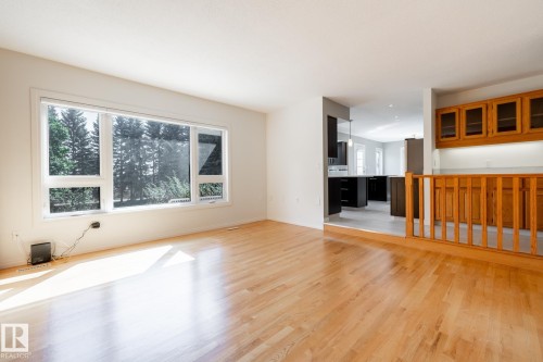 Hardwood flooring, expansive window, light-toned walls, and a wood railing - 14 Highlands Place, Wetaskiwin, AB 