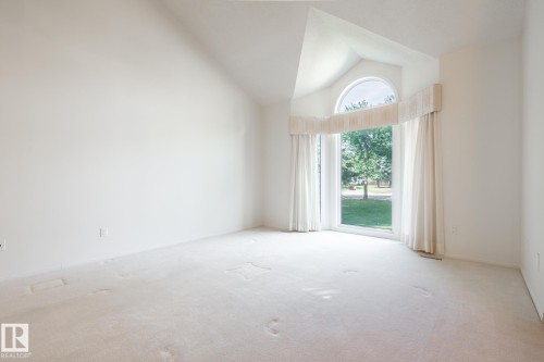 Vaulted ceiling, arched transom window, large window, light carpeting, white wall finishes - 14 Highlands Place, Wetaskiwin, AB 